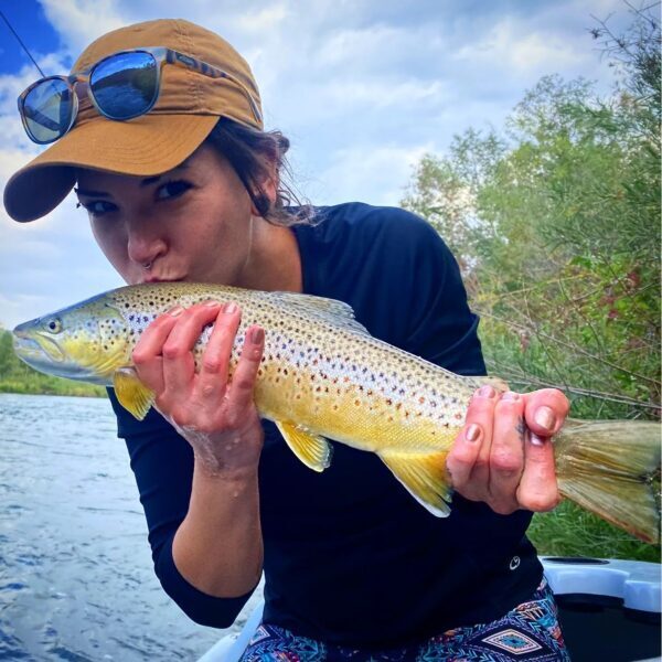 lady angler kissing a brown trout
