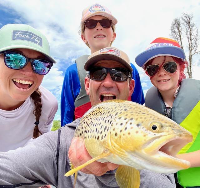 Fly Fishing Guide Josh Jablow with a Brown Trrout and family.