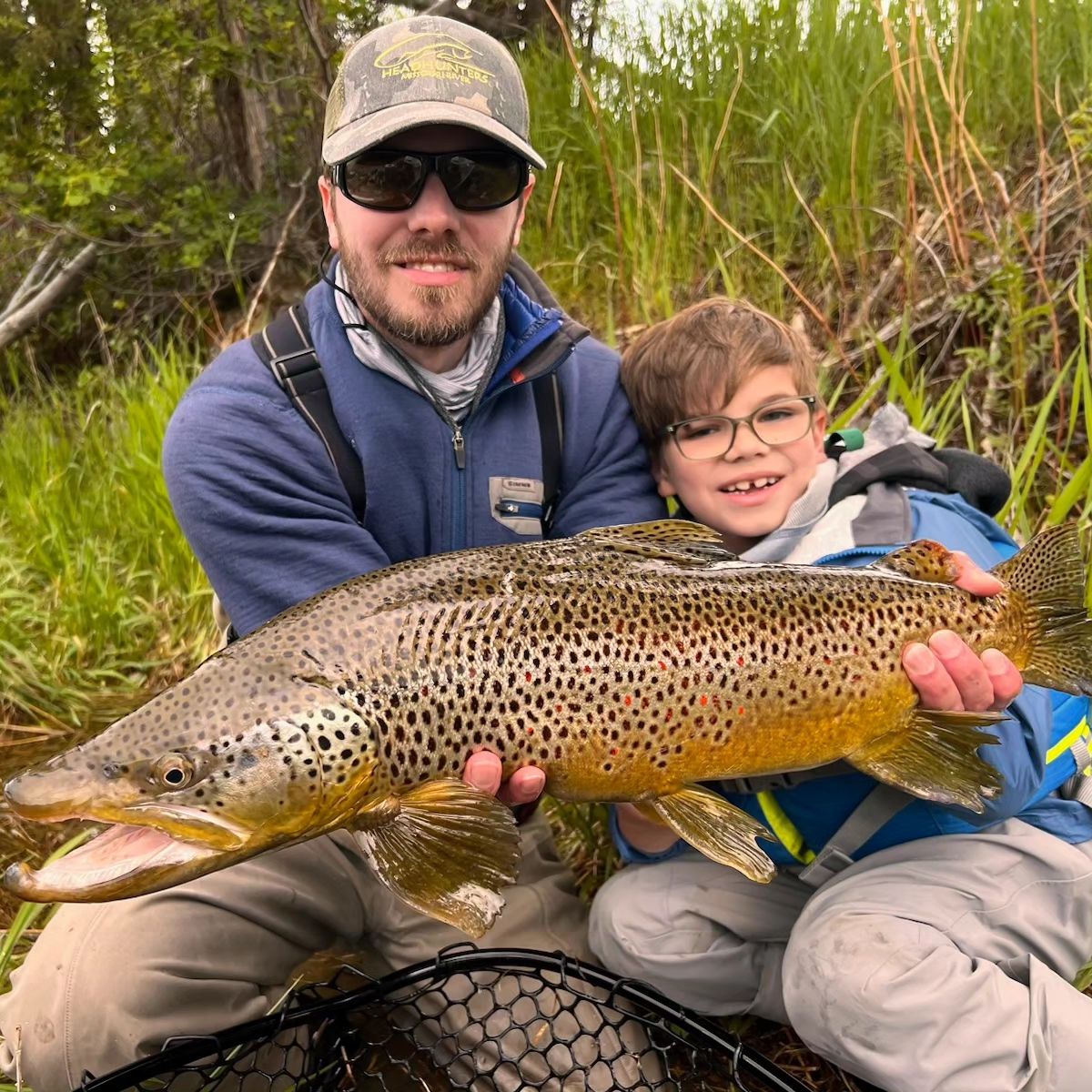 father son with big brown trout from snake river