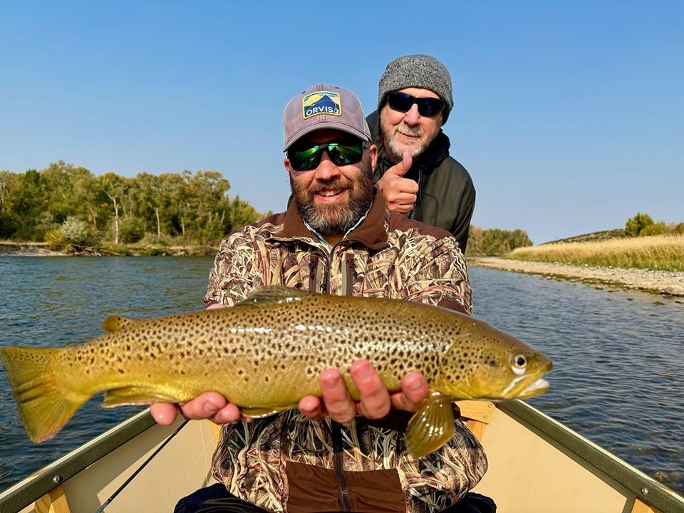 South Fork Fly Fisherman holds a Brown Trout in a Drift Boat