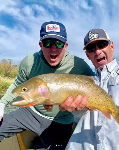 Excited anglers hold a cutthroat trout.